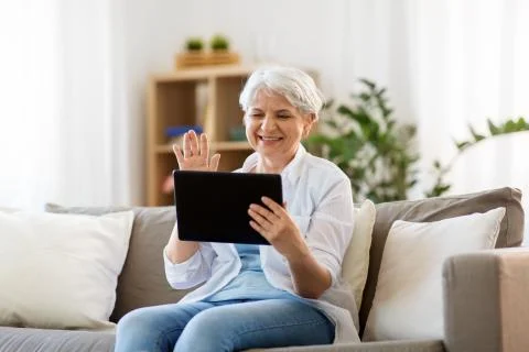 Senior woman having video chat on tablet pc Stock Photos