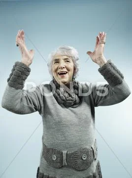 A Senior Woman With Her Arms Raised In Celebration