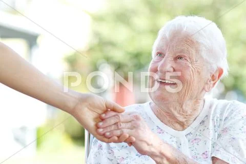 Senior woman holding hands with caretaker Stock Photos