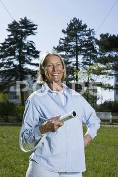 A senior woman holding a tennis racket Stock Photos
