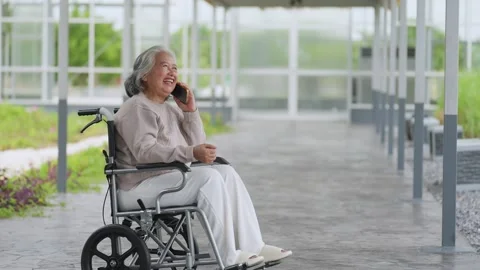 Senior woman laughs while using phone in wheelchair Vídeo Stock 345216286