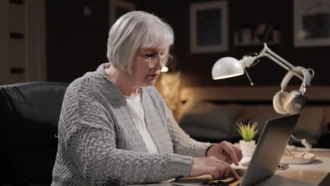 Senior woman learning to use computer. Mature woman unsure PC user with gray 動画素材 273293426