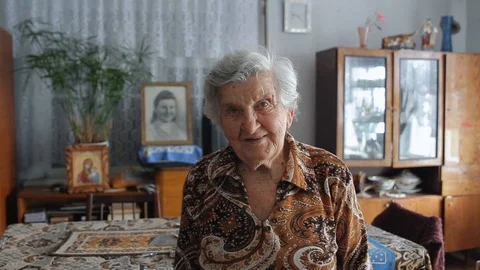 Senior woman looking at camera, posing at old soviet union apartment, close u Stock Footage 127786356