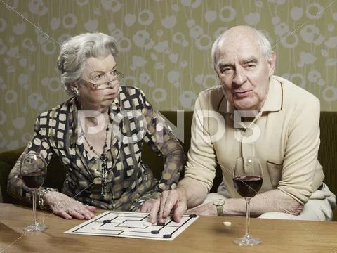 Senior woman looks shocked by man's muehle tactics Stock Photos
