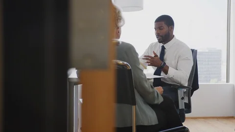 Senior Woman Meeting With Male Financial Advisor In Office Stock Footage
