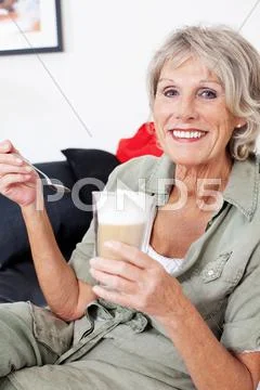Senior woman with milky macchiato coffee Stock Photos