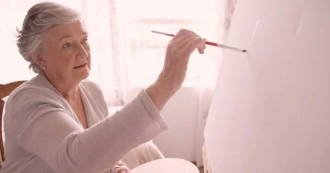Senior woman painting on canvas Stock Footage