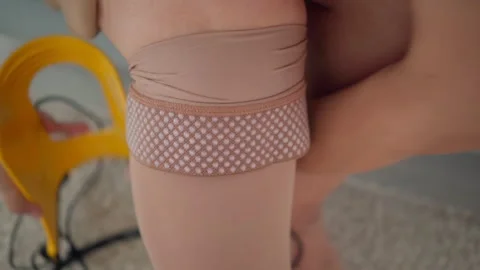 Senior woman pulling compression stocking over leg using assist frame at home Stock Footage 321707532