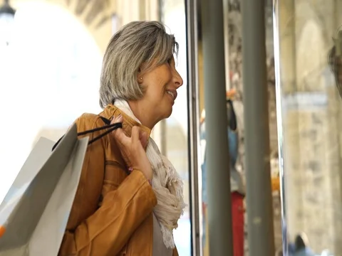 Senior woman on a shopping day looking at shop windows Stock Footage