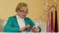 Senior woman sits on a divan and uses white mobile phone HD Footage