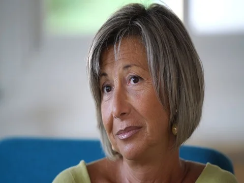 Senior woman sitting in armchair, having a conversation Stock Footage