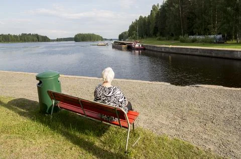 Senior woman sitting by the Konnuskosken kanava canal , Finland Stock Photos