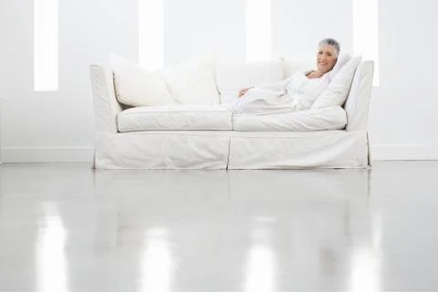Senior Woman Sitting On Sofa Stock Photos