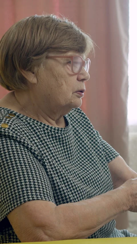 Senior woman sitting on a sofa using a remote control Stock Footage 327365774