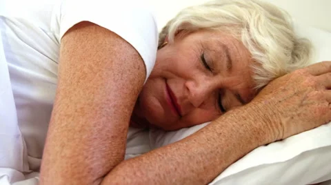 Senior woman sleeping in her bed Stock Footage