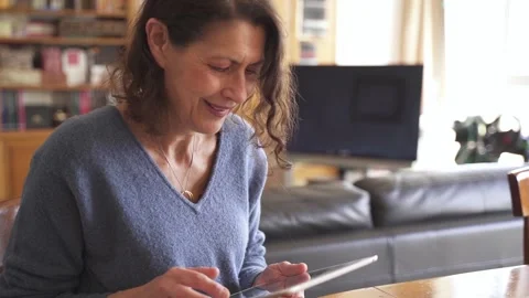 Senior woman smiling at tablet during video call Stock Footage