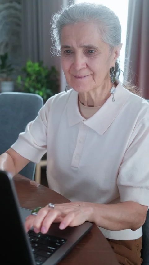 Senior Woman Smiling while Using Laptop Computer at Home Stock Footage 337007924