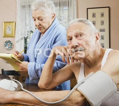 Senior woman taking husband's blood pressure Stock Photos