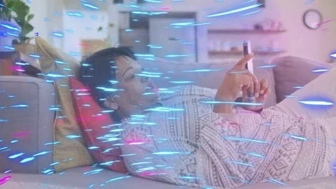 Senior woman tapping cell, scrolling through tech on couch, blue-pink streak Stock Footage 333602571