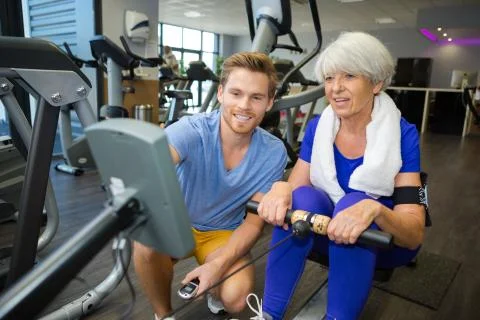 Senior woman training pilates with instructor Stock Photos