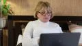 Senior woman types text uses laptop. Woman with notebook HD Footage
