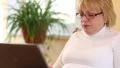 Senior woman types text uses laptop. Woman with notebook HD Footage