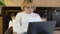 Senior woman types text uses laptop HD Footage