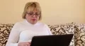 Senior woman types text uses laptop. Woman with notebook HD Footage