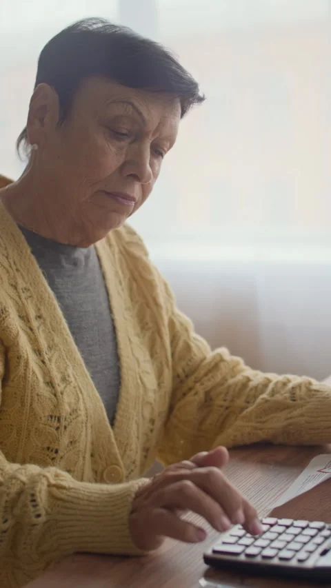 Senior Woman Using Calculator While Analyzing Document at Home Video stock 321861766