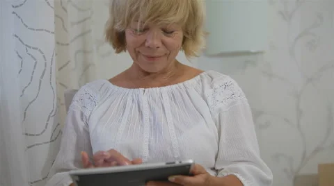 Senior woman using computer tablet at home Stock Footage 40614175