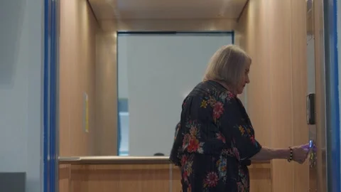 Senior woman using elevator, walking unstable, pushing button and closing Stock Footage 257646467