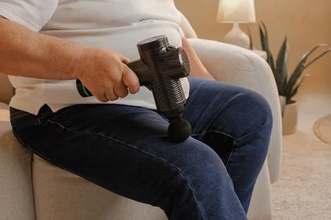 Senior Woman Using Percussion Massage Gun on Leg for Muscle Recovery Therap.. Stock Photos