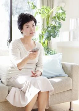 Senior woman using remote control Stock Photos
