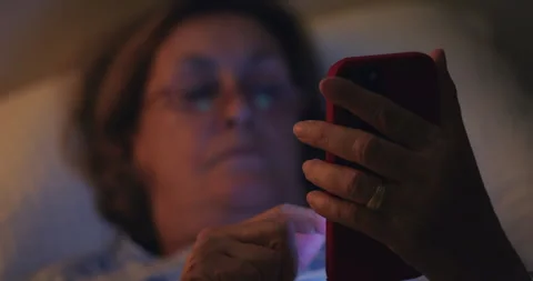 Senior woman using smartphone in bed before sleep, embracing modern technol.. Stock Footage 340974492
