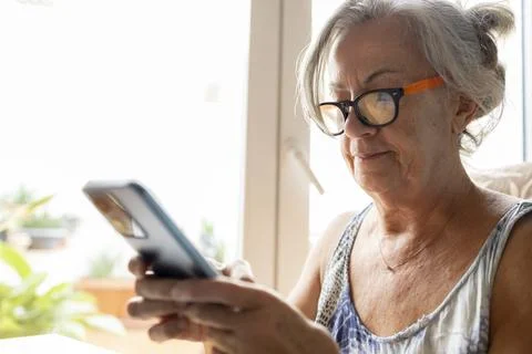 Senior woman using smartphone while wearing glasses Stock Photos