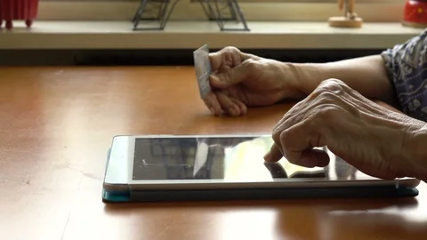 Senior Woman Using Tablet Computer and credit card, shopping online Video stock 130104294