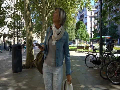 Senior woman walking in town, using smartphone Stock Footage