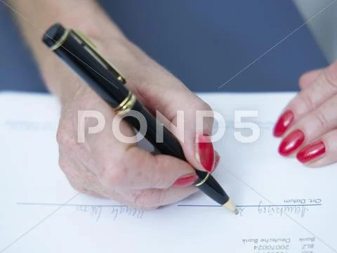 Senior Woman Writing On Document