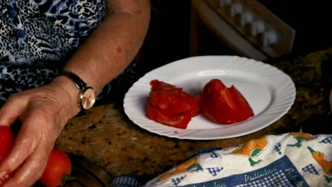 Senior woman's hands preparing salad, chopping tomato Vídeos de archivo 346922149