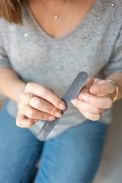 Senior woman's hands while filing her nails with a manicure file. Stock Photos