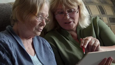 Senior women learning using digital tablet on sofa at nursing homes Stock Footage 315534490