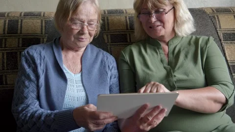 Senior women learning using tablet on sofa at home Stock Footage 316741616