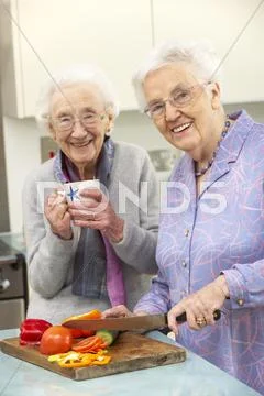 Senior women preparing meal together Stock Photos