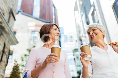 Senior women with shopping bags and coffee in city Stock Photos