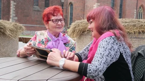 Senior women use tablet computer sitting at table in cafe Video stock 146718456