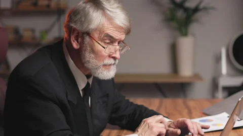 Senior worker making mistake in report on laptop in office Stock Footage 251649678