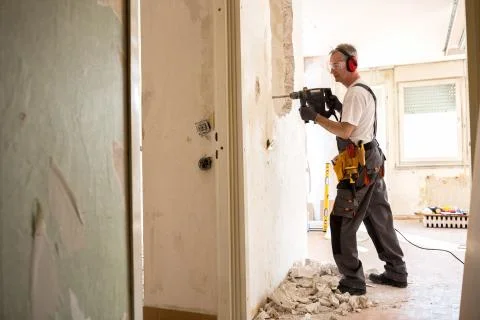 Senior worker using drill at contruction site Stock-Fotos
