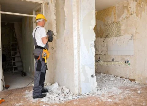 Senior worker using drill at contruction site Stock Photos