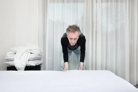 Senior working on bed making in his home bedroom for good sleeping Stock Photos