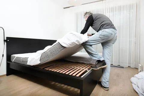 Senior working on bed making in his home bedroom for good sleeping Stock Photos